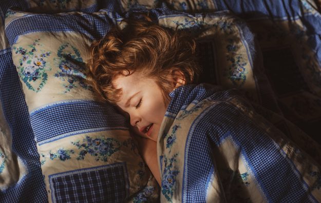 Fysiotherapie Lansingerland – Slapen Klein kind is aan het slapen in bed onder de denkens