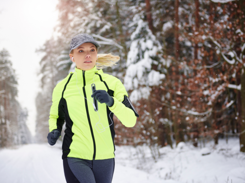 vrouw in sportkleding loopt hard door de kou om stijve spieren te voorkomen