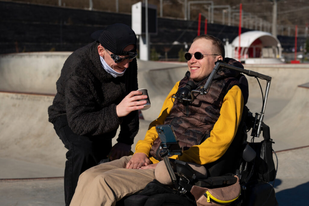 Man met ALS zit in een rolstoel en geniet van de zon.