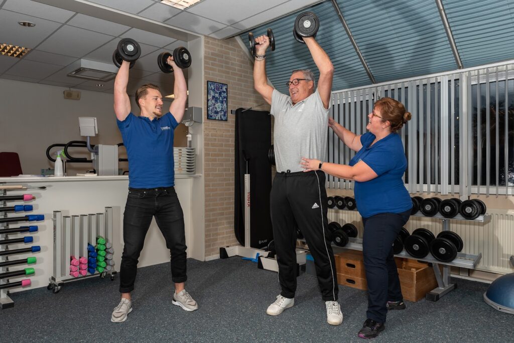 Man in zijn pensioen blijft fit door te sporten onder begeleiding van twee fysiotherapeuten.