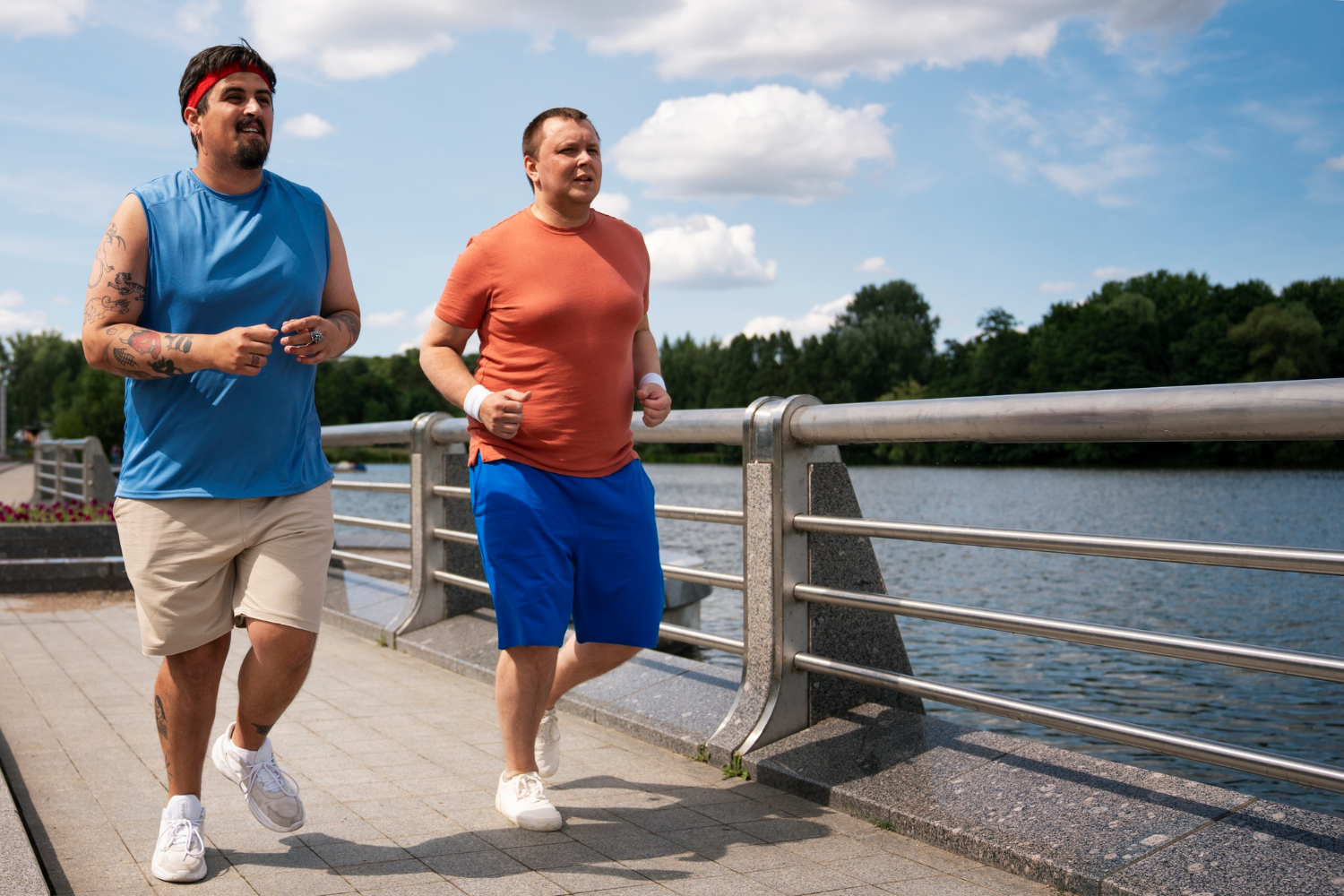 GLI Twee personen met overgewicht in een blauw shirt en roze shirt rennen over de brug boven het water en werken werken aan hun obesitas door middel van een programma met GLI