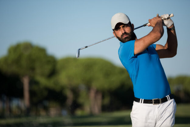 Tennisarm Man in een blauw shirt doet aan golfen zonder tennisarm