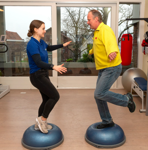 man in geel shirt die balanceert op 1 been