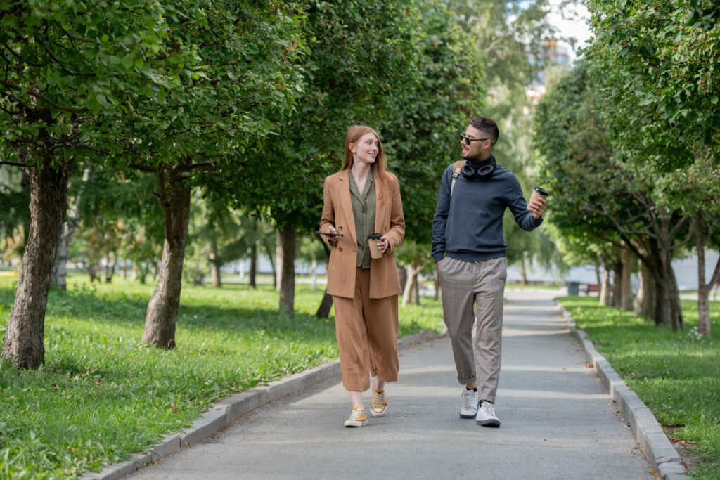 Twee vrienden zijn met elkaar aan het wandelen in een park en praten over het werk.