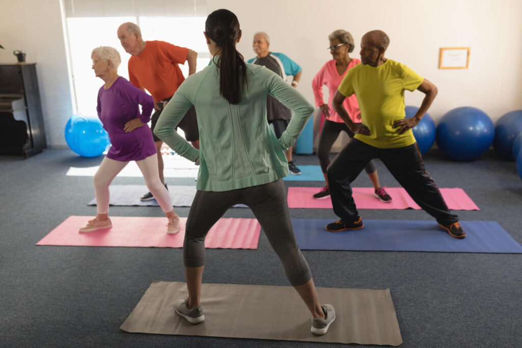 Groepje mensen probeert stress en rugklachten te voorkomen in de oefenzaal door oefeningen uit te voeren zoals pilates.